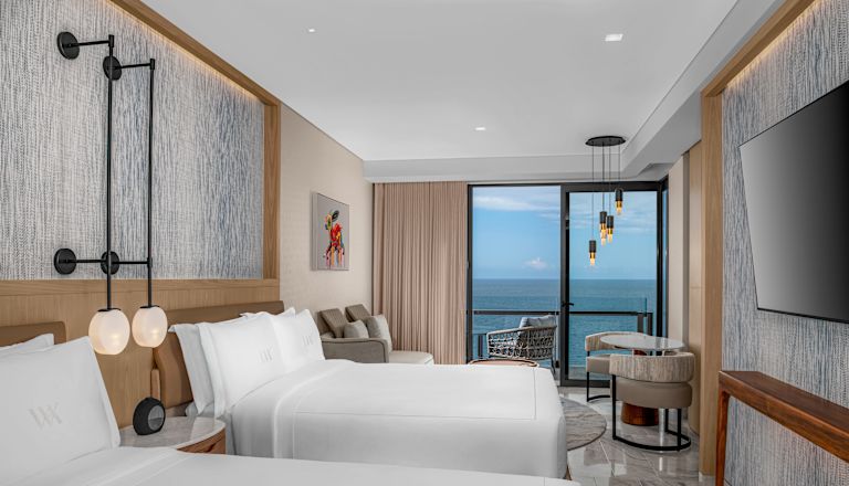 Two queen beds ocean front deluxe guestroom with wall mounted TV