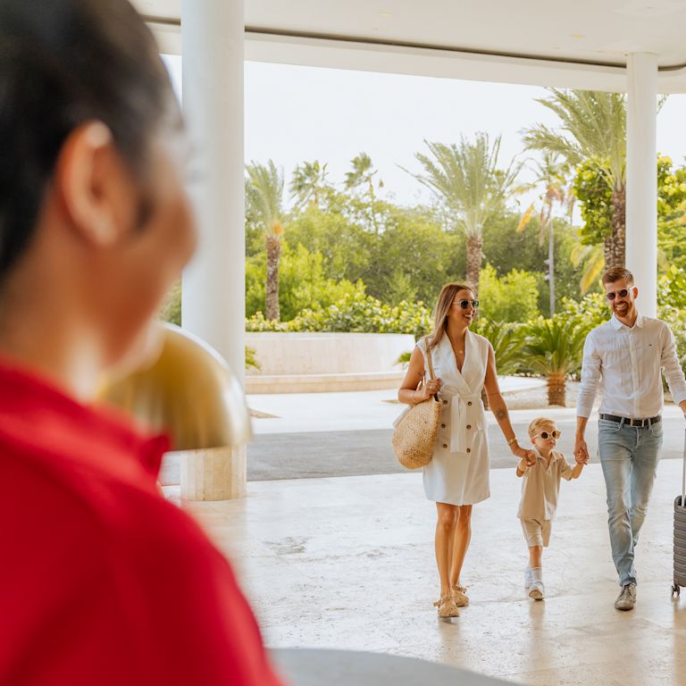 família caminhando até o balcão de recepção