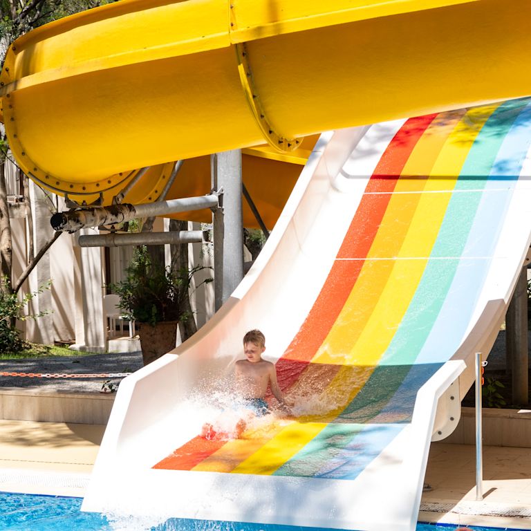 Boy on a Slide Landing on the Pool