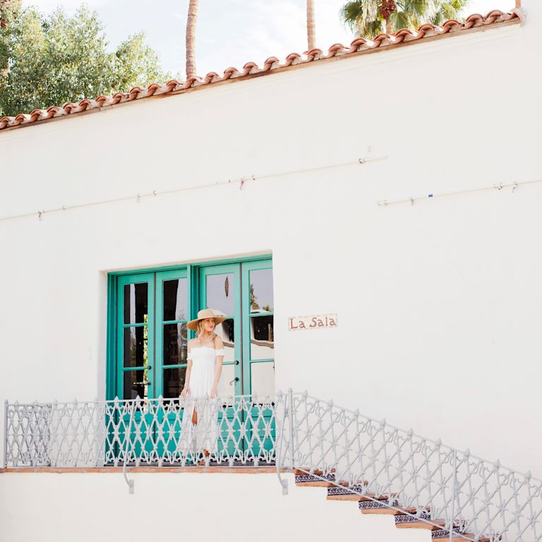 Woman standing outside white building