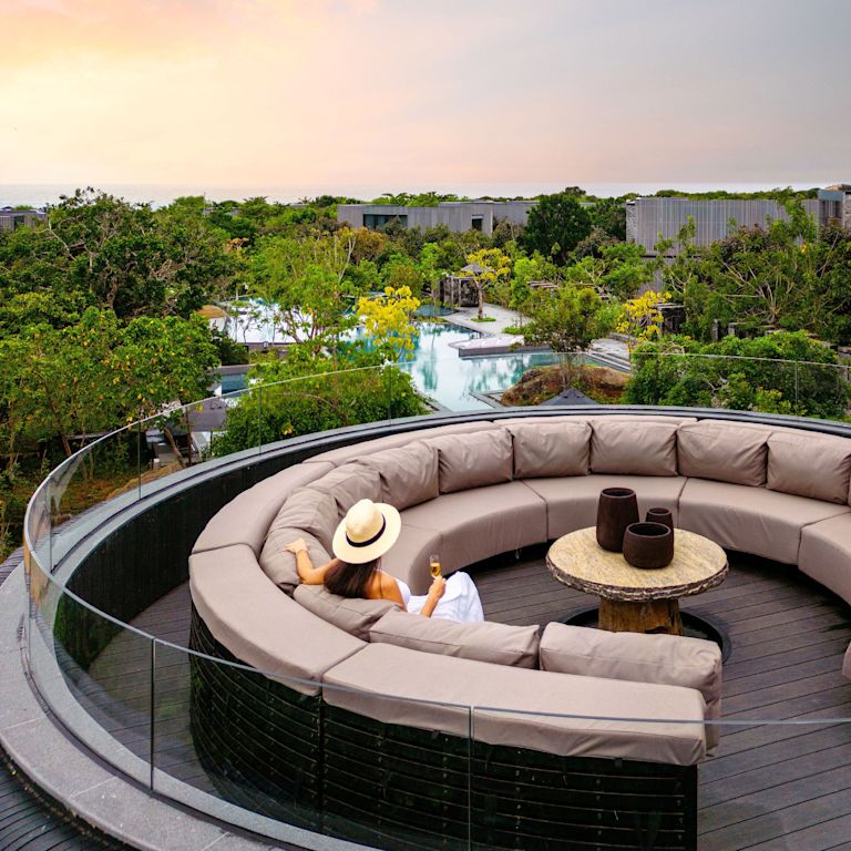 woman in outdoor sitting area enjoying views of the pool and sunset