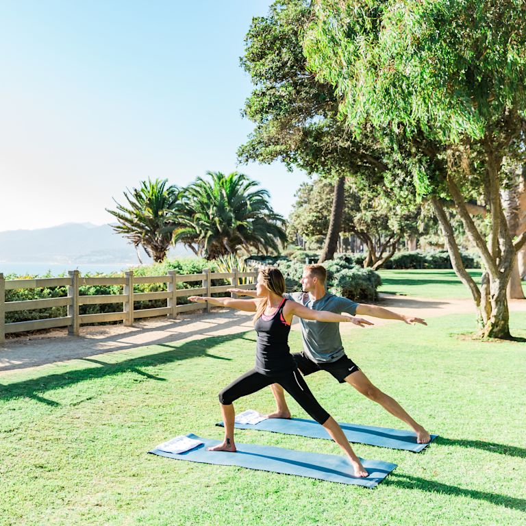 Casal fazendo yoga no gramado