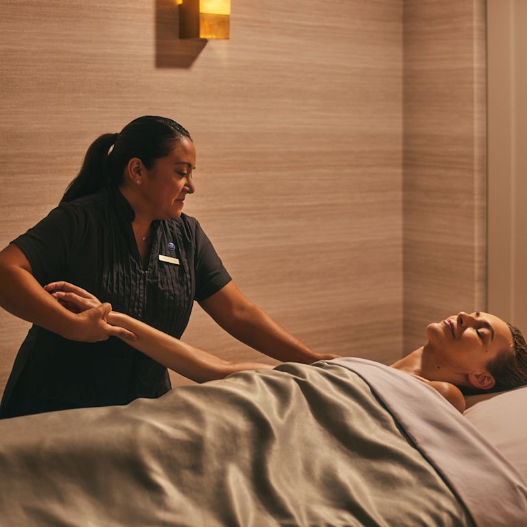 Mujer en una sala de tratamiento de spa recibiendo un masaje del masajista