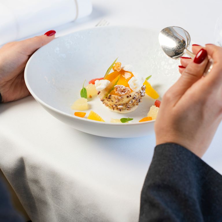 Donna che cena al ristorante Gordon Ramsay au Trianon