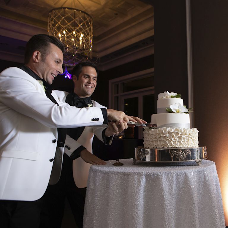 Casal cortando um bolo no dia do casamento