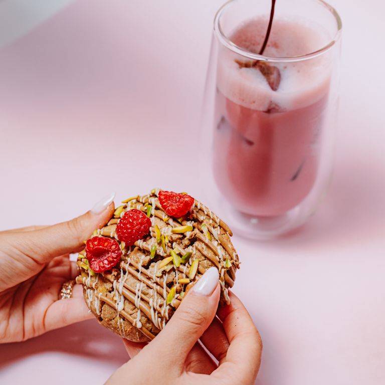 Một người phụ nữ đang cầm bánh quy, trong khi người khác đang rót nước ép lên ly tại Ledoux