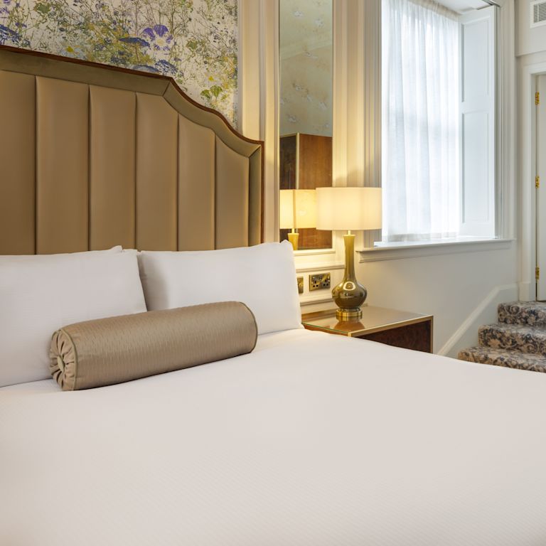 guest room, 1 queen bed , night table, lamp, stairs to bathroom