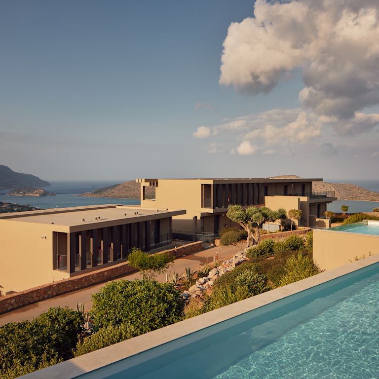 Esterno del Greco Levant con piscina affacciata sull'oceano e sulle montagne.