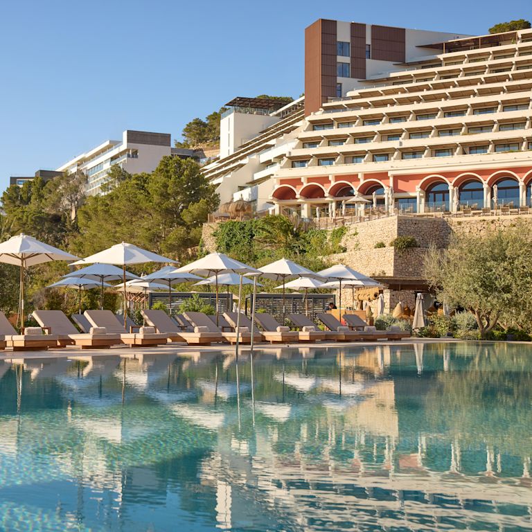 Outdoor Pool Area with Lounge Chairs under Umbrellas