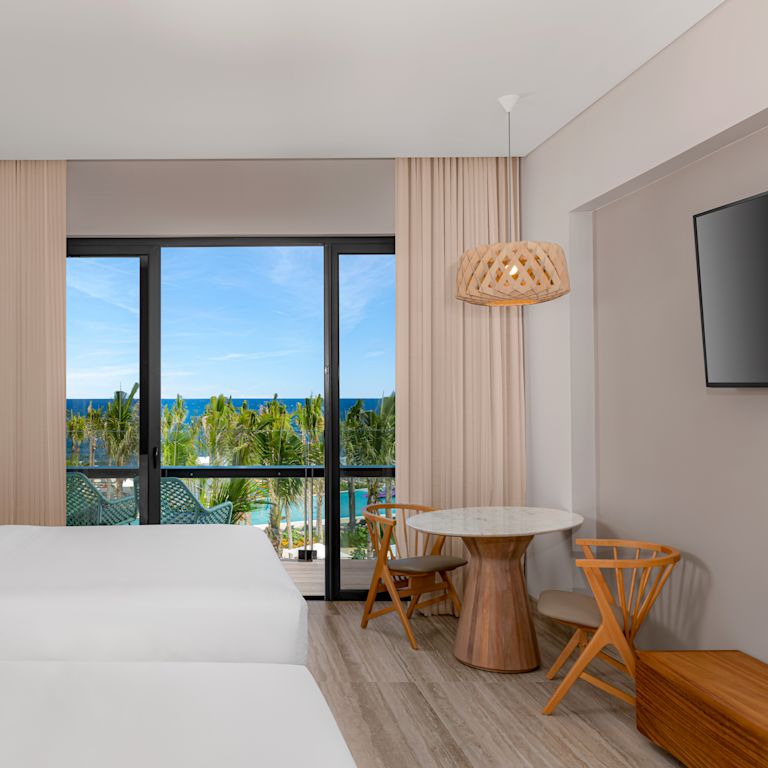 Habitación con dos camas, sala de estar y balcón