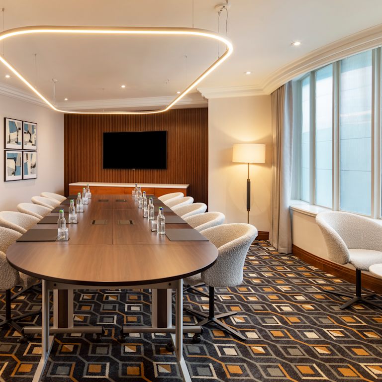 Thiết lập phòng Argyll Suite với bàn hình bầu dục cho cuộc họp với mười khách và truyền hình