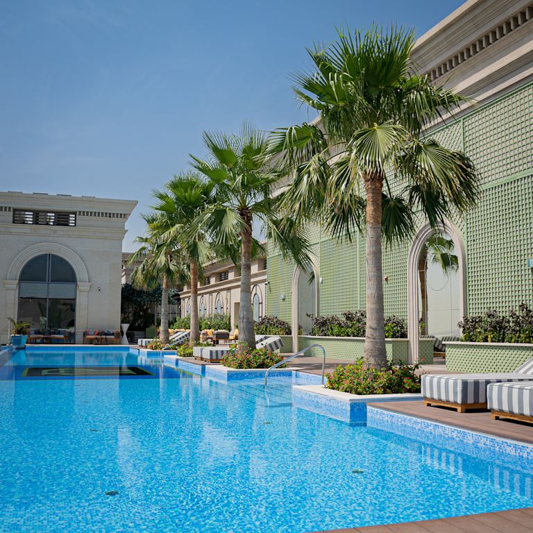 Piscina esterna con lettini e alberi