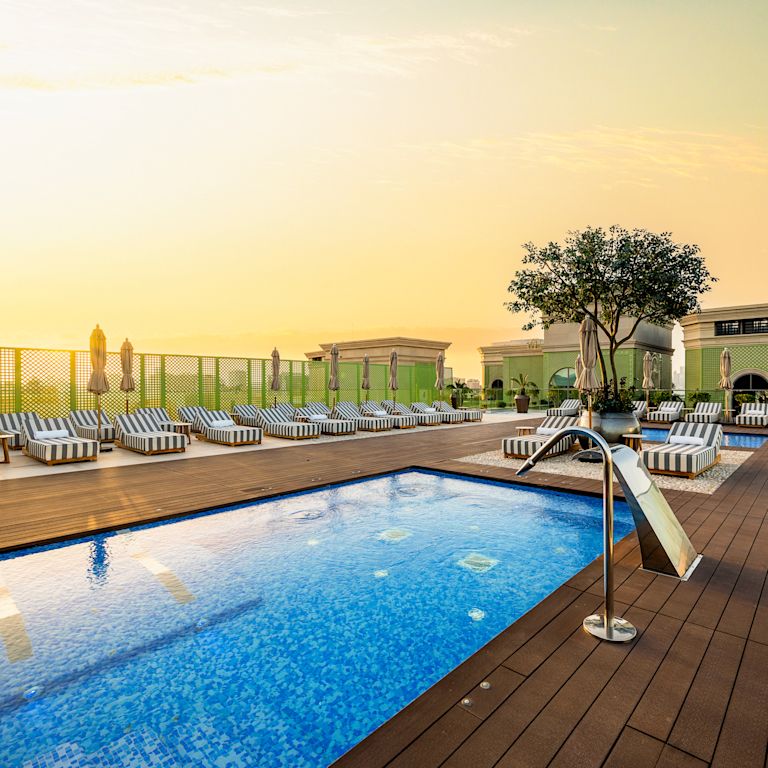 Piscina esterna con corrimano e lettini