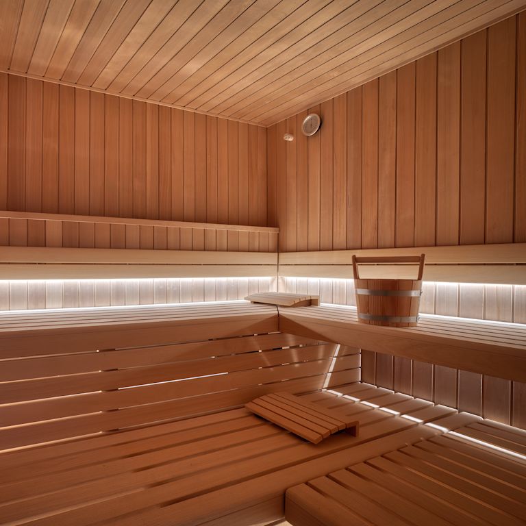 Dry sauna in hotel spa with multiple levels for sitting or laying down.