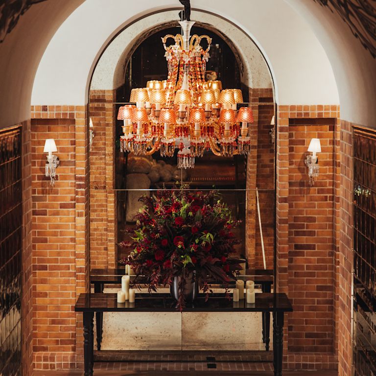 Entrée de la réception de l'hôtel avec composition florale et lustre