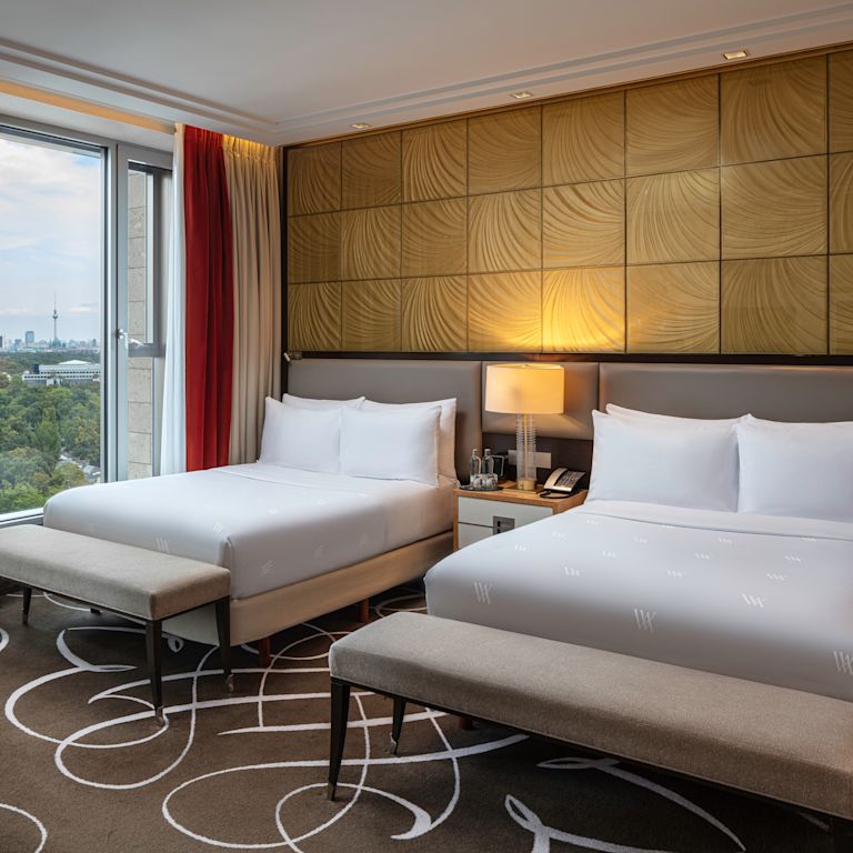 2 beds in room with lamp