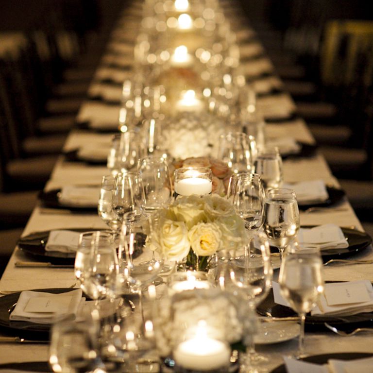 Mesa grande configurada para jantar para uma comemoração de casamento