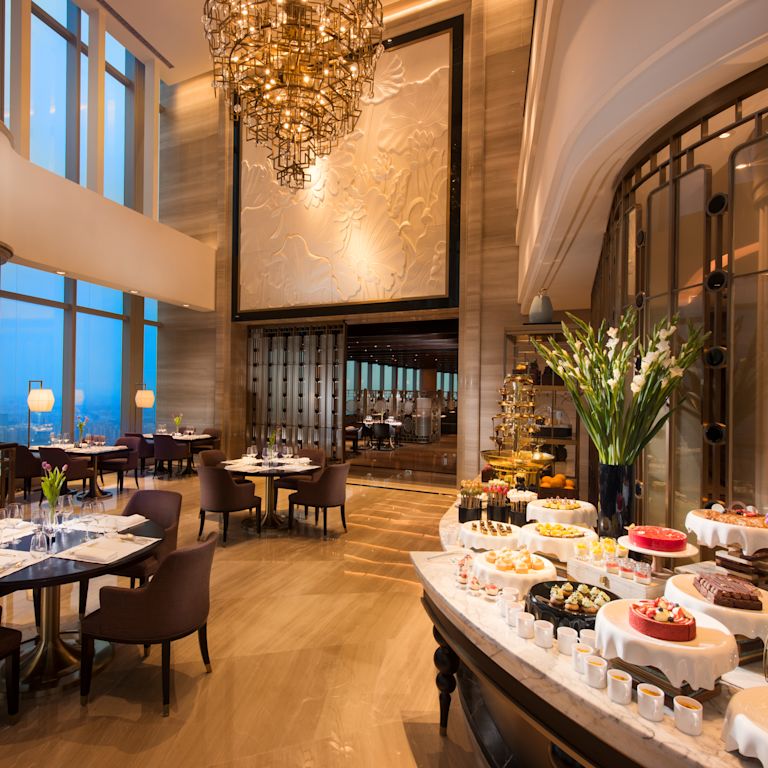 Dining Buffet Area with Various Desserts on Buffet Table and Dining Tables and Chairs