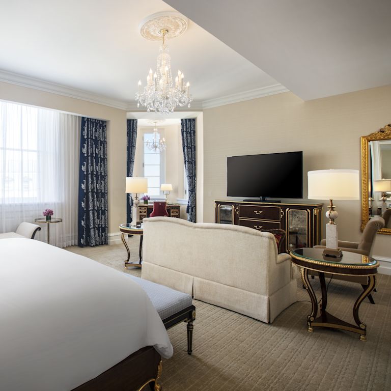 Junior suite bedroom and sitting area with sofa and TV