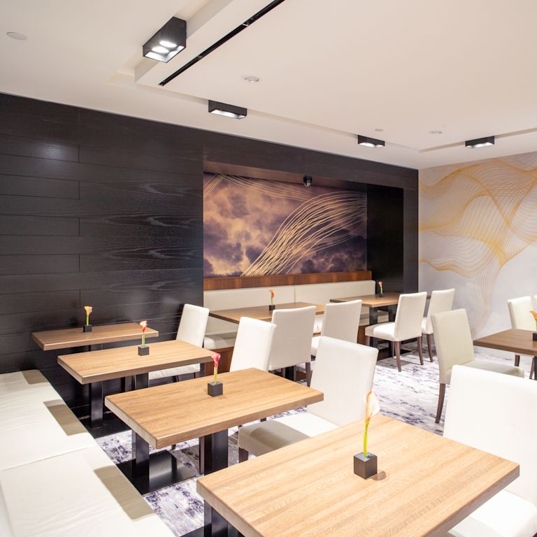 Dining area setup with white chairs and art on wall
