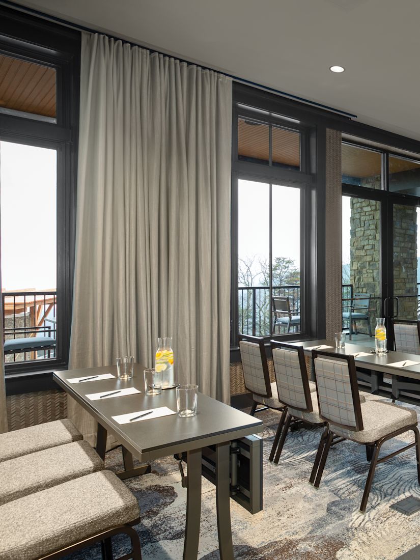 Dogwood meeting room in a classroom setup, with floor-to-ceiling windows along the side of the space.-transition