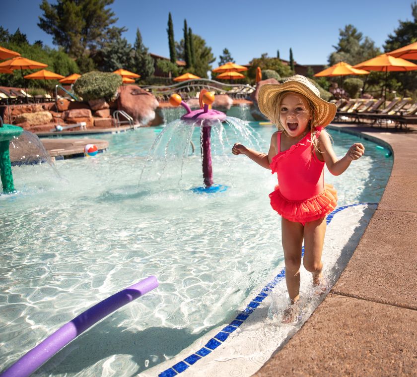 little girl laughing and wading in the pool