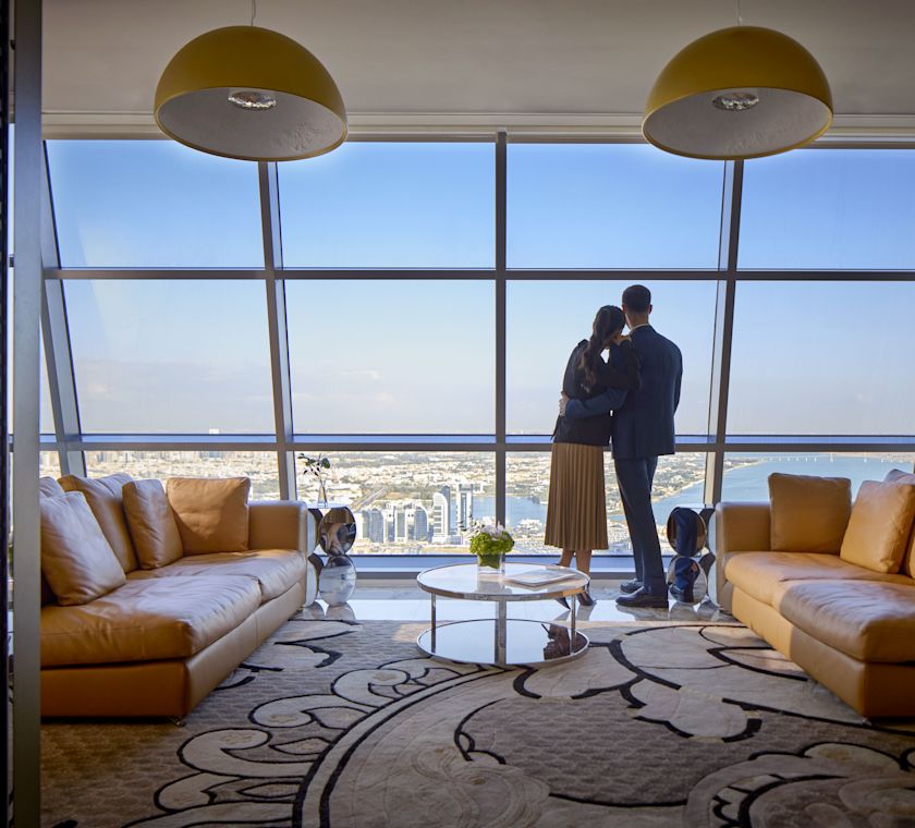 Man and woman standing in lounge area looking out of window