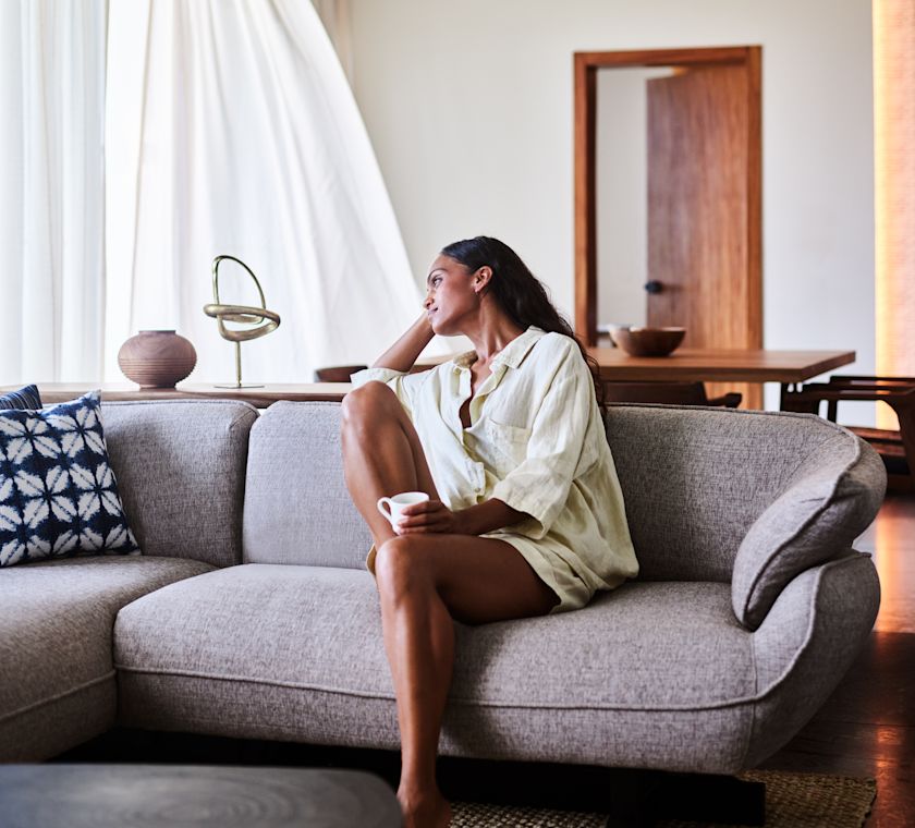 Woman relaxing on comfortable chair in guest room
