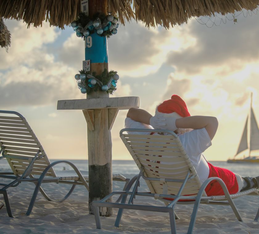 Santa lying on deck chair looking out on to shoreline