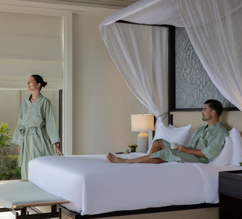 Man and woman relaxing in robes in guest room