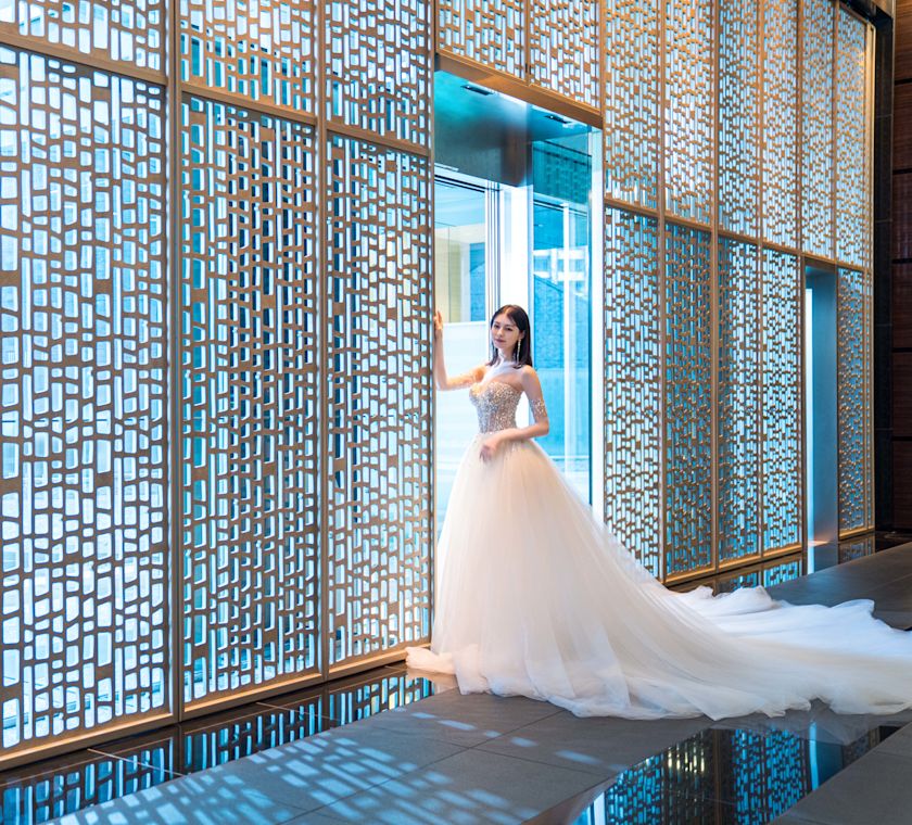 Une personne vêtue d'une robe de mariage pose pour une photo