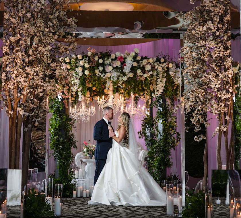 Couple Getting Married Indoors in an Area Decorated with Flowers and Candles