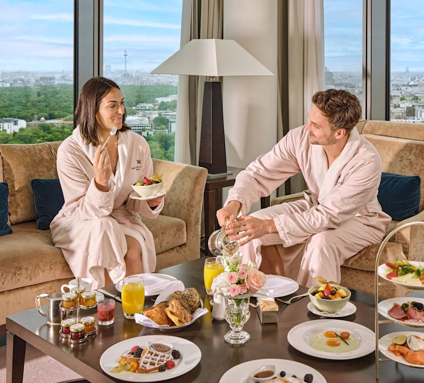 Pár si užívá snídani v pokoji v obývacím prostoru apartmá