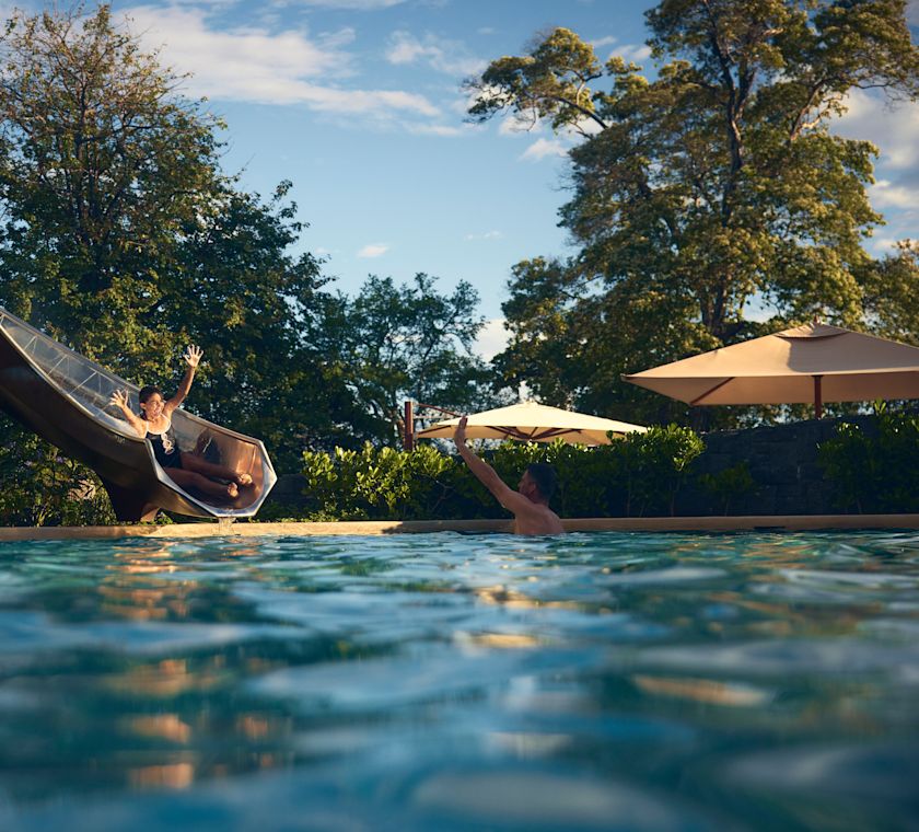 在室外泳池區的女孩在滑梯上