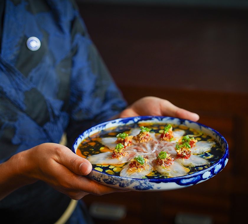 waiting staff holding plate of food