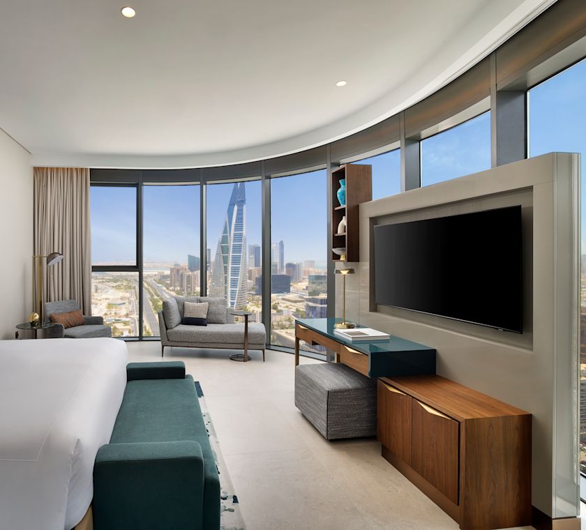 guest suite bedroom, 1 king bed, tv, sofa, window views of the city