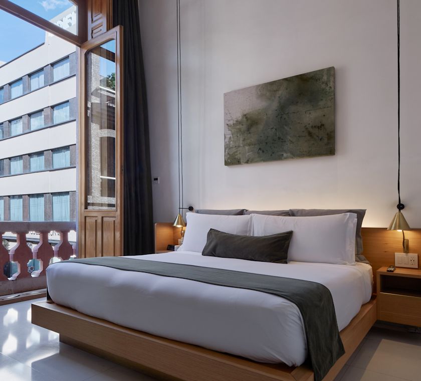 Chambre avec lit et portes doubles donnant sur le balcon.