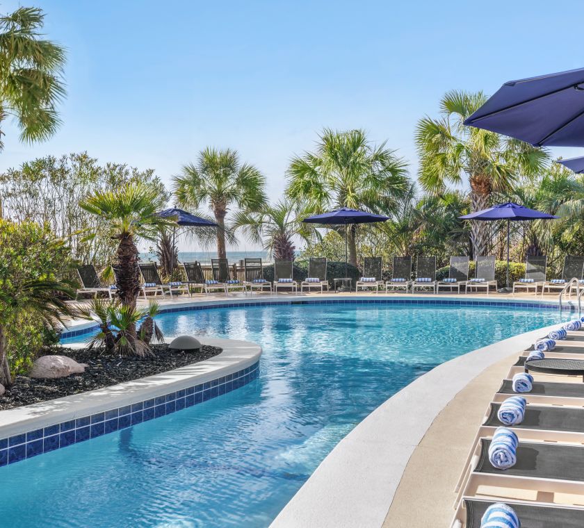 Beautiful outdoor pool featuring ample seating for guests to relax and ocean view.