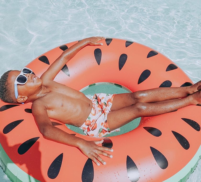 Boy floating in pool on inflatable ring