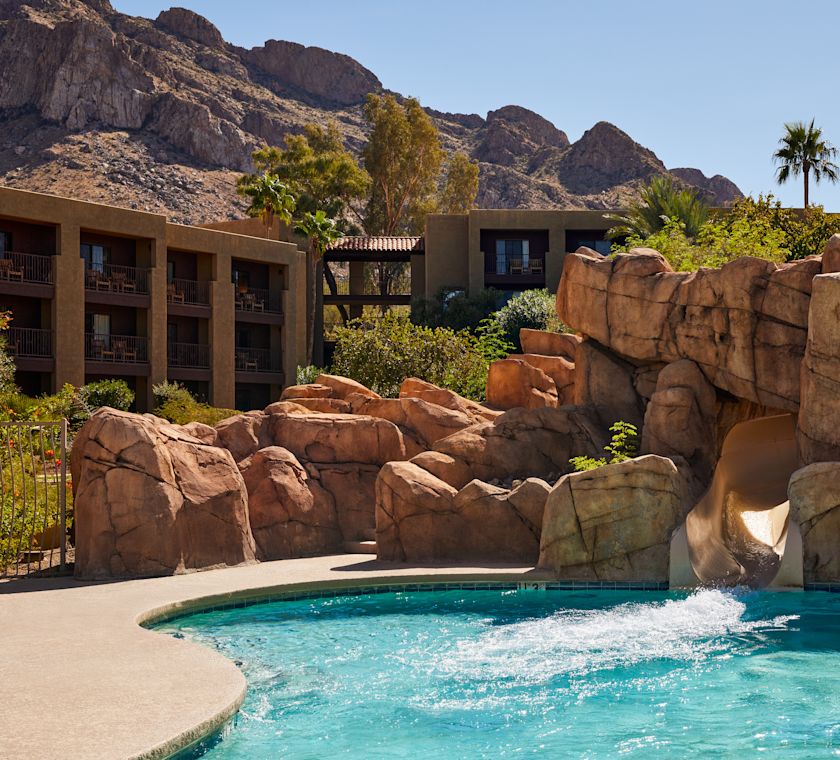 Water Slide in a Pool Area with Mountains in Background