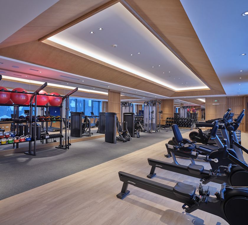 Fitness centrum s kardio přístroji a zvonky na konvici