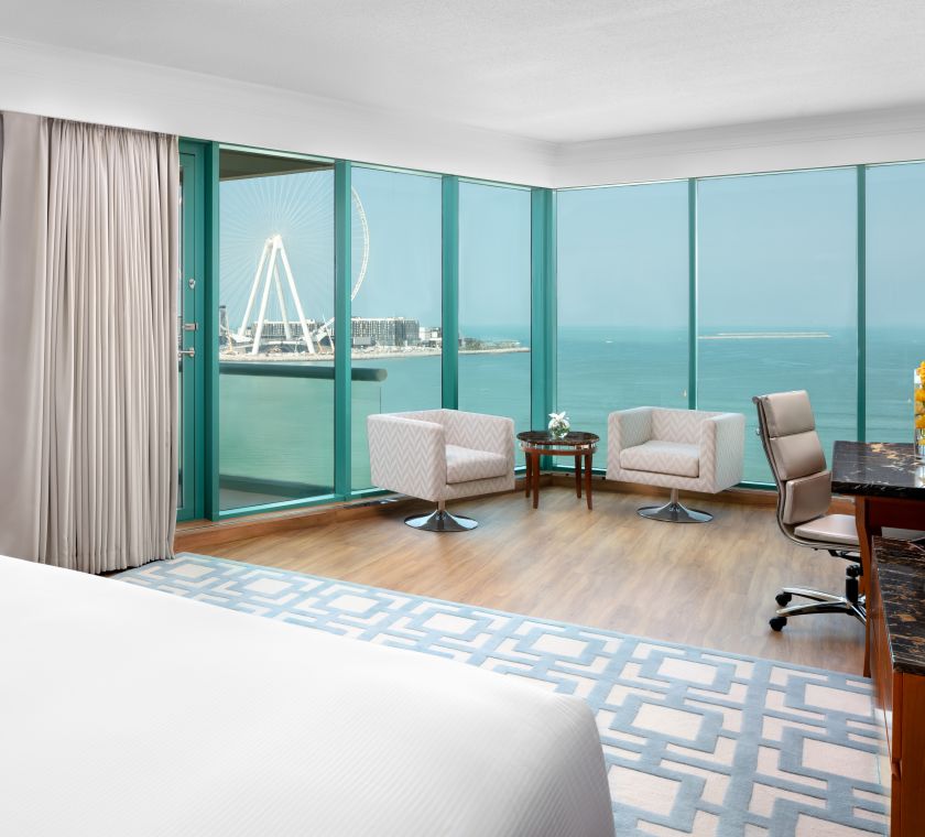 Suite met uitzicht op zee, groot bed, balkon, bureau en zitgedeelte