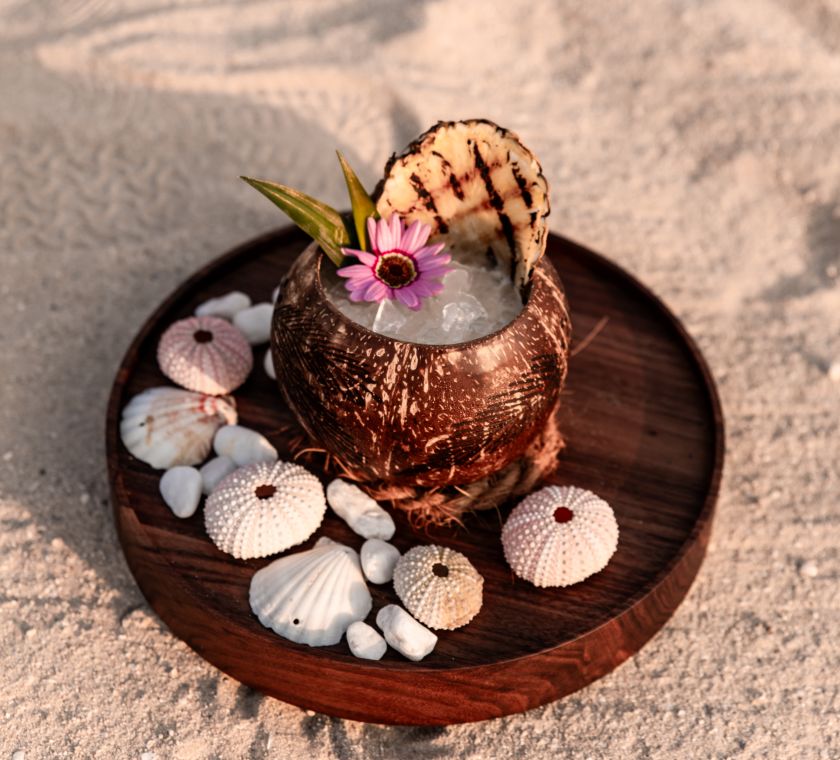 ビーチのココナッツシェルで楽しむカクテル