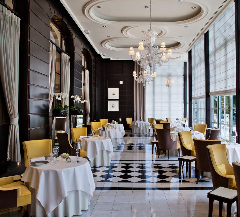 Coin repas avec de grandes fenêtres au restaurant Gordon Ramsay au Trianon
