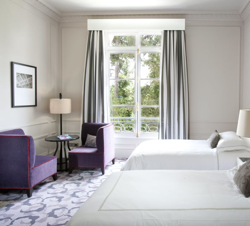 Zwei Betten im Hotelzimmer mit Sitzbereich und Gartenblick
