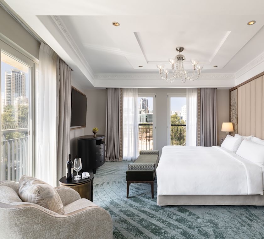 Großes Bett in einer Suite mit Sitzbereich und Balkon