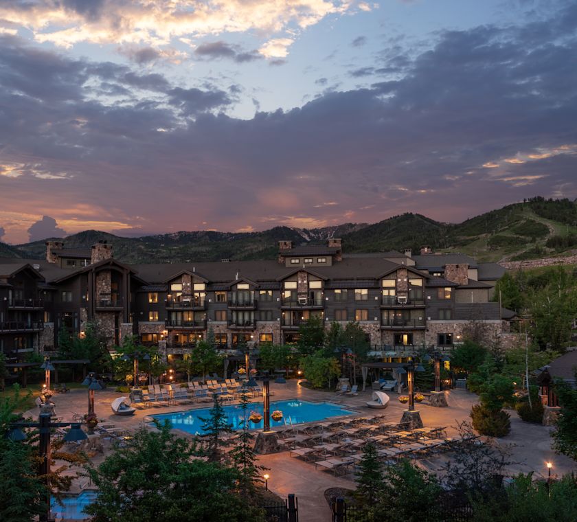 view of hotel exterior and pool at dusk