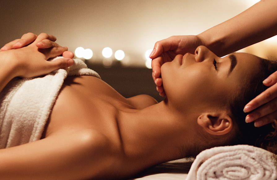 Woman lying on a treatment bed enjoying a facial-transition