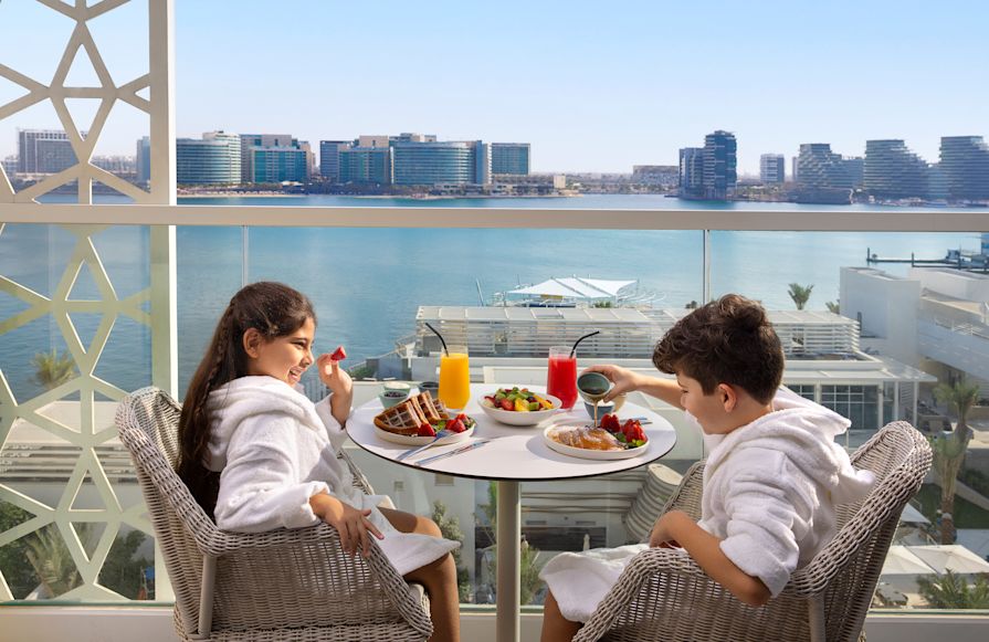 Kids sitting on balcony with breakfast-transition