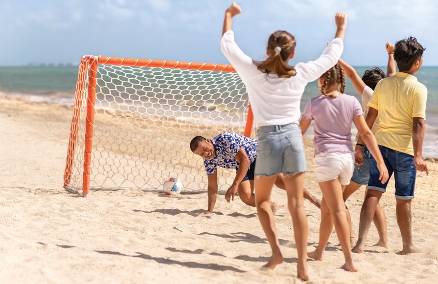 Children cheer and play soccer on the beach-transition